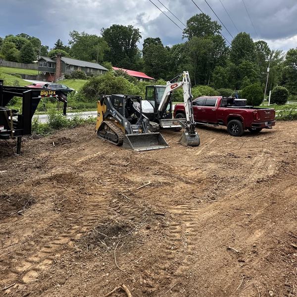 Cleared lot with a skid steer, mini excavator and pickup truck