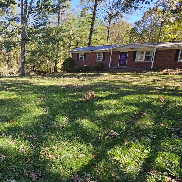 The same front yard cleared of fallen trees and debris